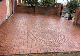 a brick driveway with a circular pattern with a compass laid out in the middle