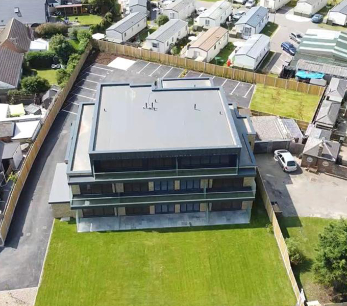 the overhead view of a modern square building in the middle of a suburban area